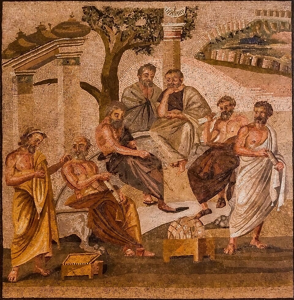 A Roman mosaic of seven robed philosophers seated and standing in discussion beneath a tree, with columns and a walled city behind them